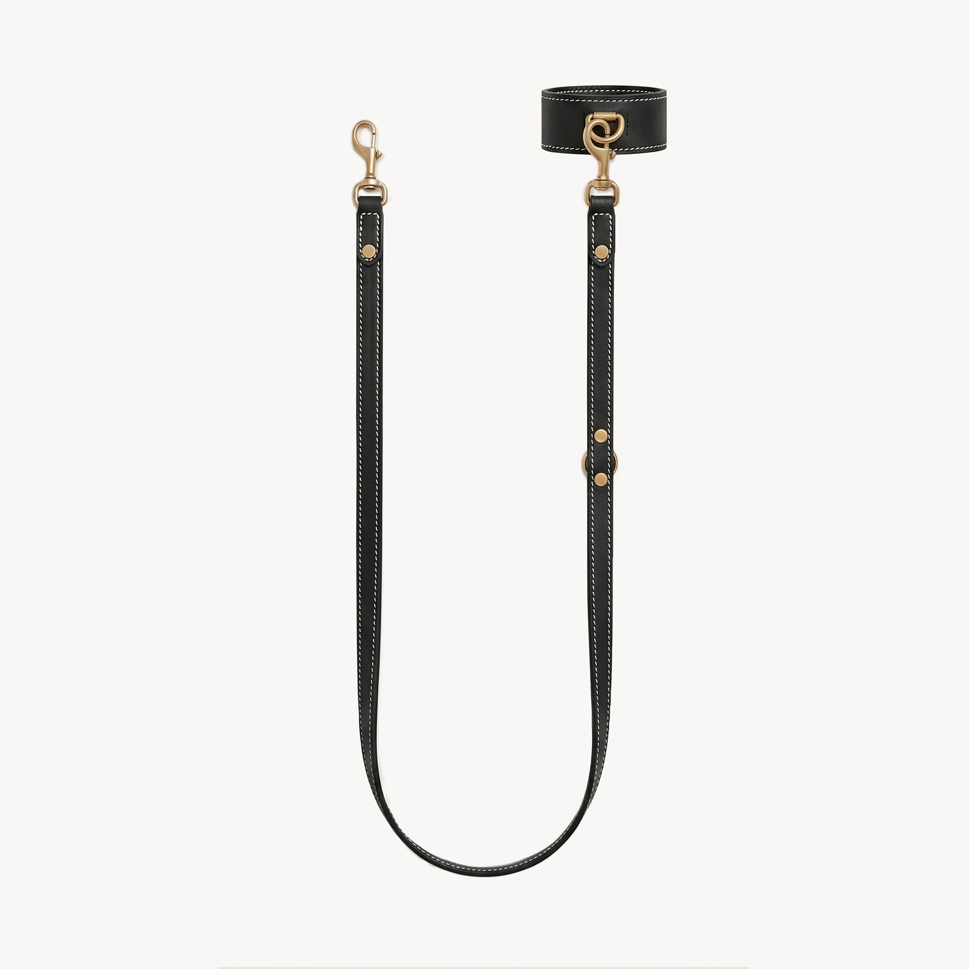 Black wrist and lead set by Arvak + Sól featuring a double-ended leash, cuff bracelet, and adjustable straps.