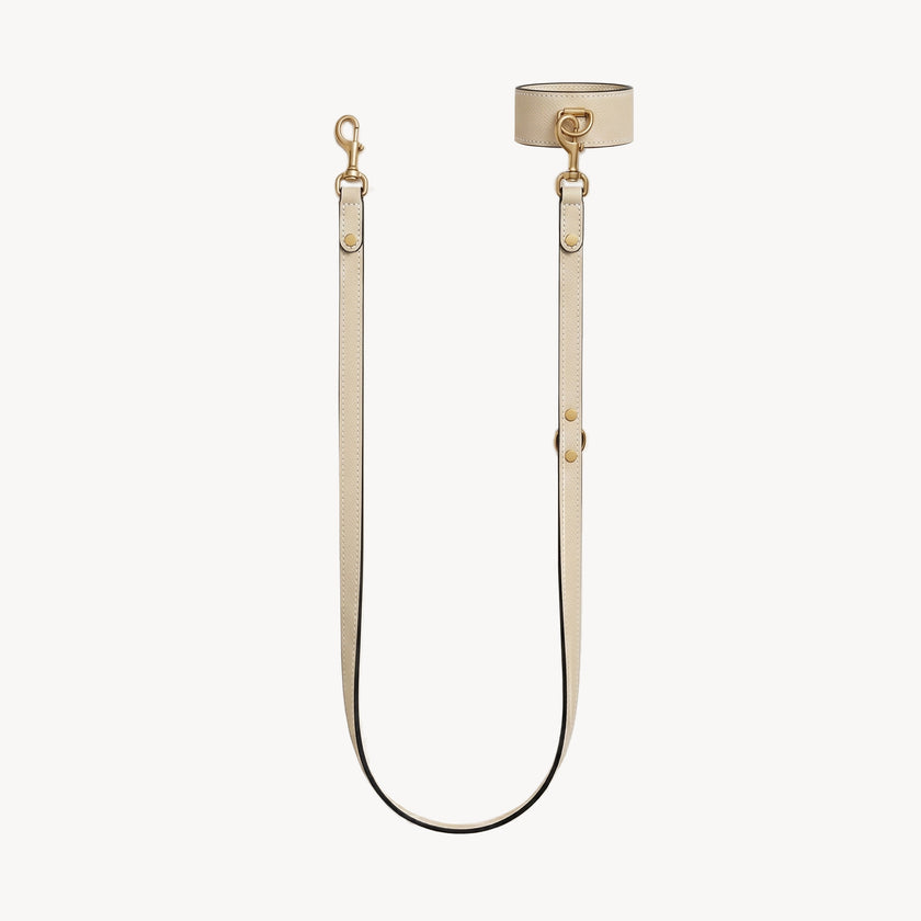 Cream-colored Arvak + Sól wrist and lead set with double-ended leash, cuff bracelet design, and adjustable straps.