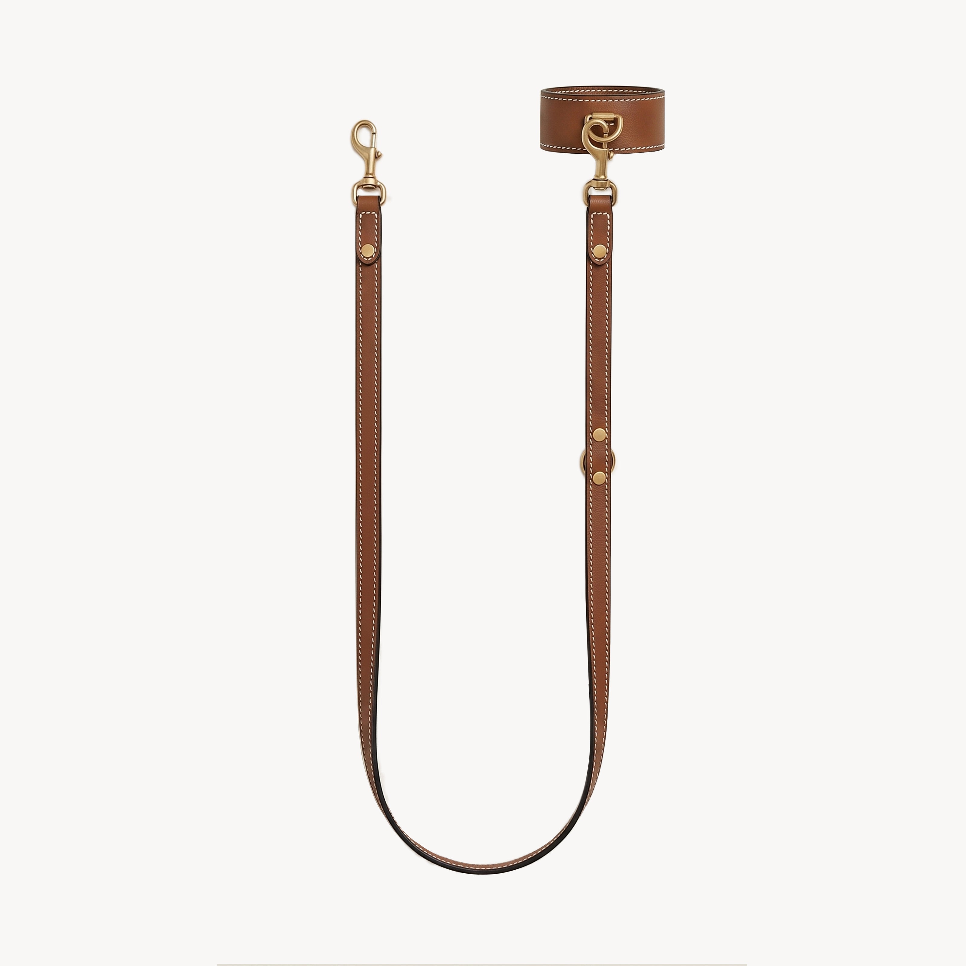 Arvak + Sól wrist and lead set featuring double-ended leash, leather cuff bracelet, and saddle-style hardware in natural tones.