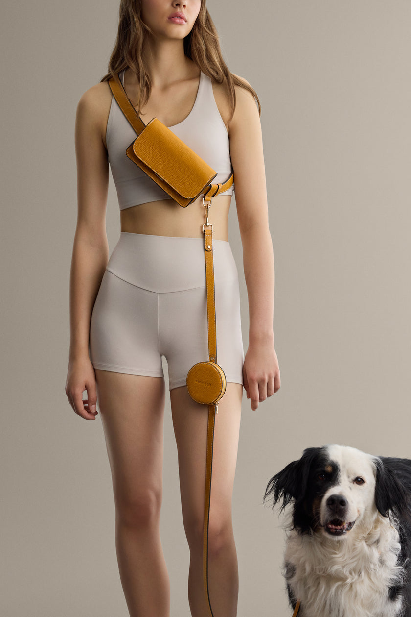 Black leather belt bag by Arvak + Sól, featuring adjustable strap and compact design, shown worn around the waist.